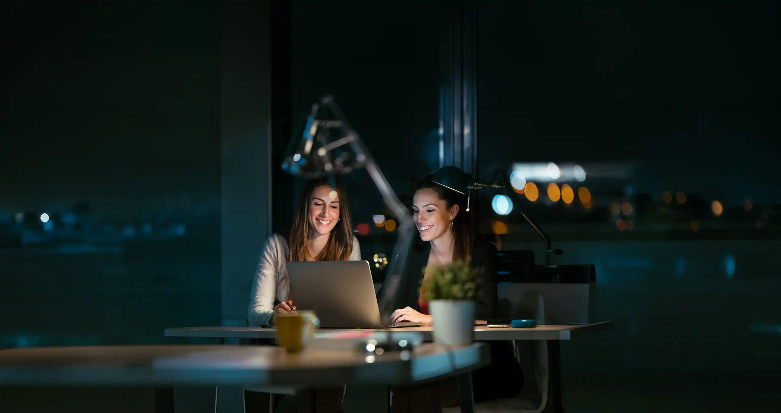 Employees reviewing AI-generated output on a laptop, illustrating the hidden AI management overhead behind everyday automation